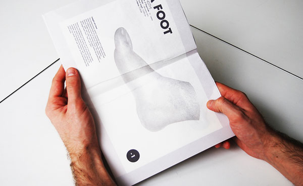 Two hands unravelling the booklet to twice the size revealing a piece of content about the foot